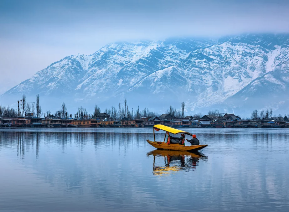 Shikara boats floating on Dal Lake with the Himalayas in the background during sunset in Srinagar, Kashmir
